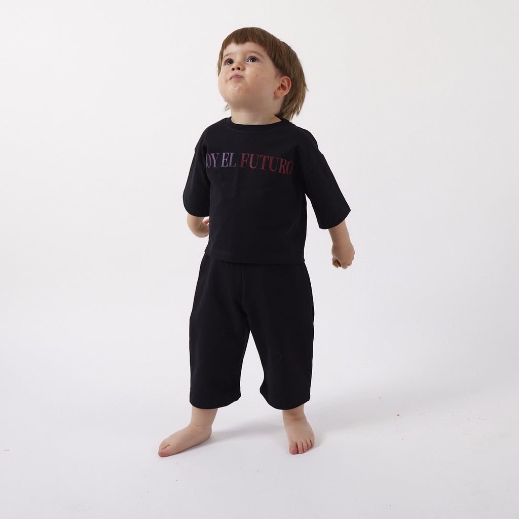 Peque de 2 años de frente con el Pantalón Pantera negro talla 1 de calce holgado y largo 3/4