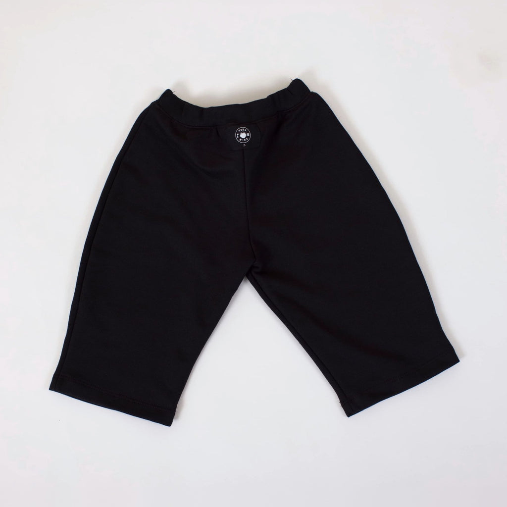 Pantalón Pantera negro visto por la espalda, con la etiqueta Yoru Kids por fuera en la pretina