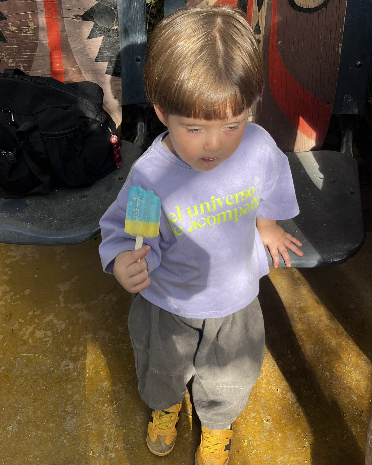 Ren (casi 3 a&ntilde;os) con Polera Universo talla 2, sosteniendo una paleta de hielo