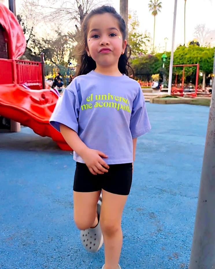 Elena (4 a&ntilde;os) con Polera Universo talla 2, de pie en una plaza