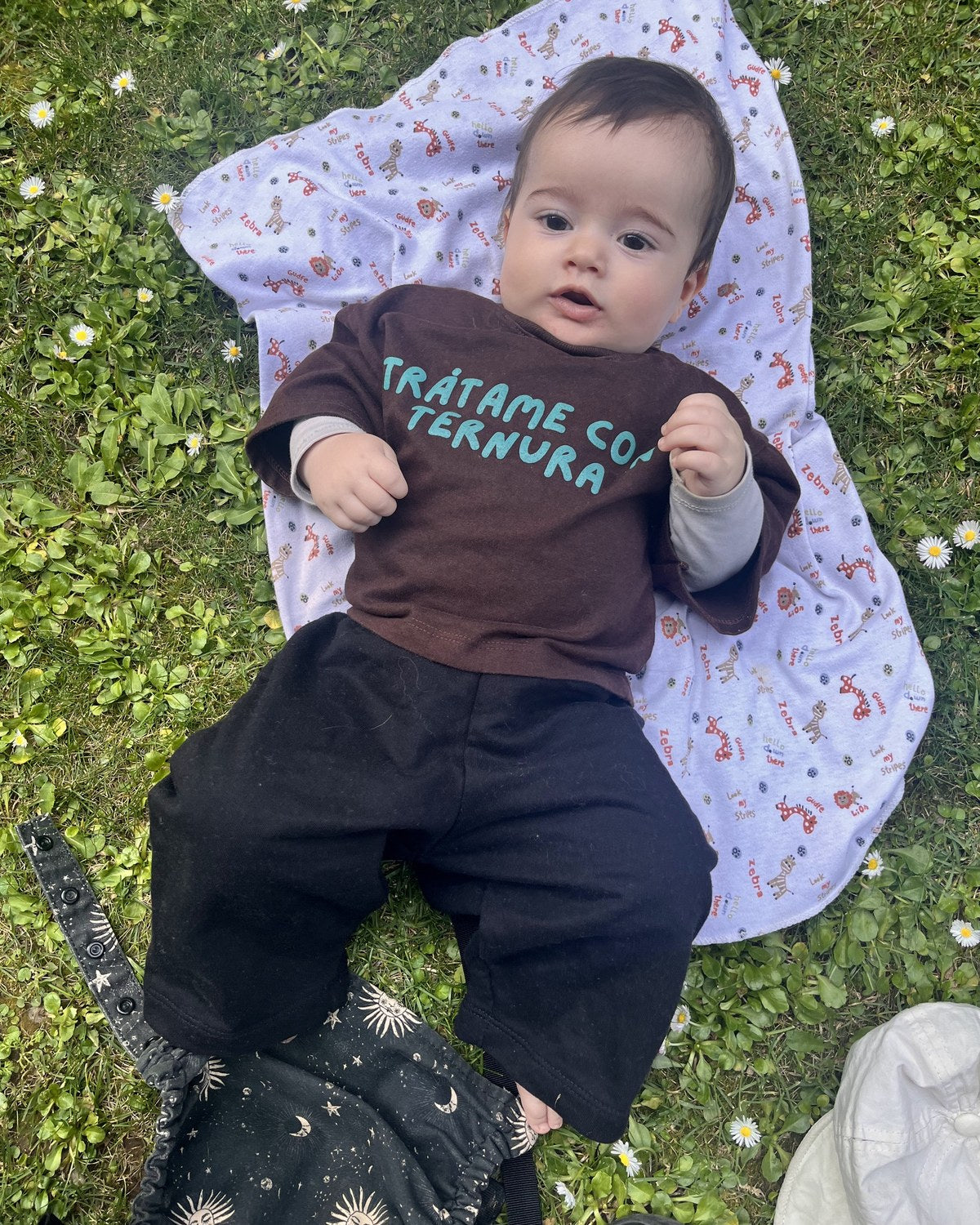 Ali (8 meses) acostado en el pasto con Polera Ternura y Pantal&oacute;n Pantera, ambos talla 1