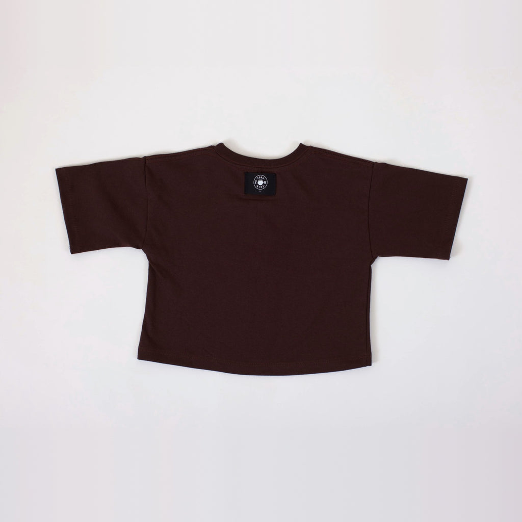 Polera Ternura café oscuro vista por la espalda, con la etiqueta Yoru Kids por fuera