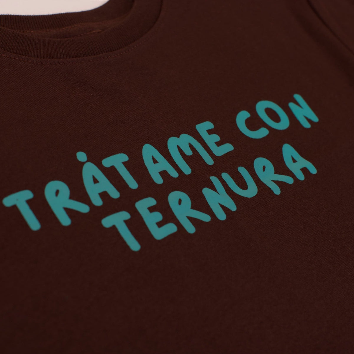 Detalle del estampado calipso "Trátame con ternura" sobre la Polera Ternura café oscuro