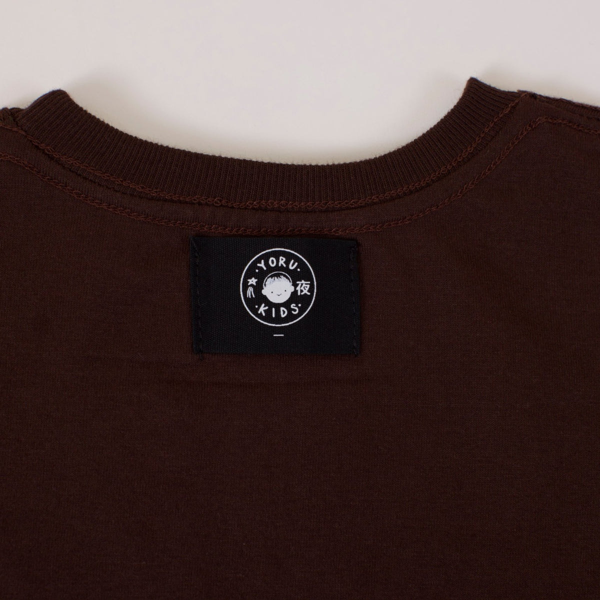 Detalle de la etiqueta Yoru Kids por fuera, bajo el cuello de la Polera Ternura