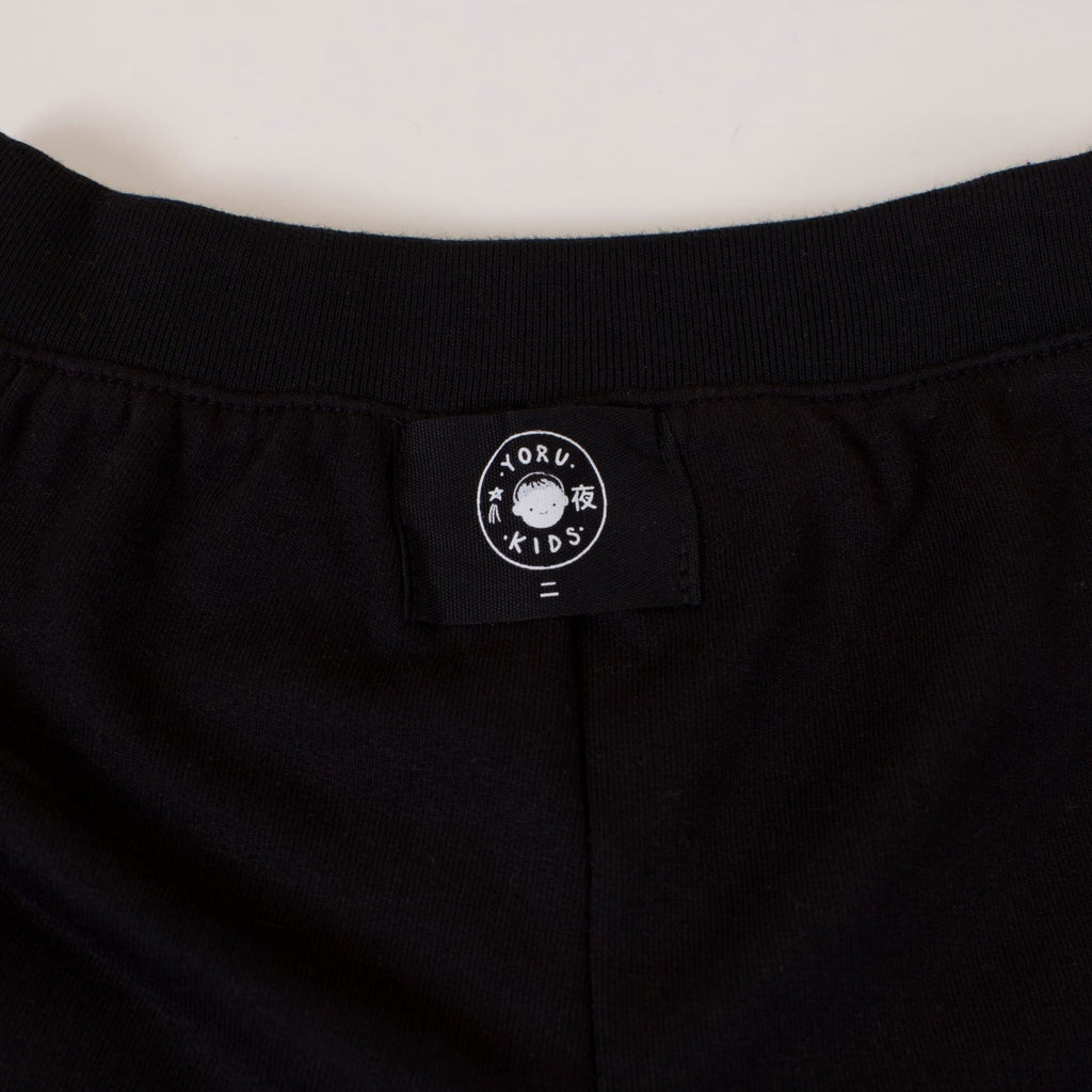 Detalle de la etiqueta Yoru Kids por fuera en la pretina del Short Dinosaurio